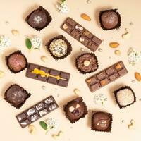 Craft natural candies and mini chocolates pattern with nuts and flowers. Sweet food, healthy dessert top view, flat lay photo