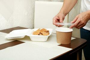 mother collects lunch for the child, cookies in the lunchbox, soup in the soup container. photo