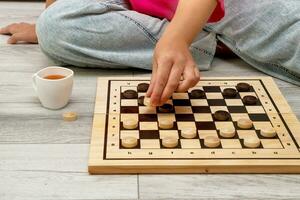 woman playing checkers at home sitting on the floor photo