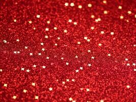 Red christmas glitter background with stars. Festive glowing blurred texture. photo