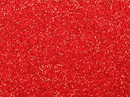 Red christmas glitter background with stars. Festive glowing blurred texture. photo