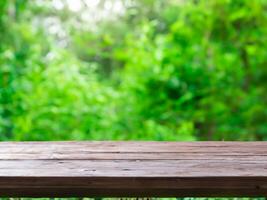 empty wooden tabletop podium in garden open forest, blurred green plants background with space. organic product presents natural placement pedestal display, spring and summer concept photo