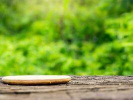 empty wooden tabletop podium in garden open forest, blurred green plants background with space. organic product presents natural placement pedestal display, spring and summer concept photo