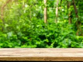 empty wooden tabletop podium in garden open forest, blurred green plants background with space. organic product presents natural placement pedestal display, spring and summer concept photo