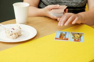 en un cafetería, un niña pone fuera tarot tarjetas foto