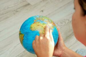 woman looking at the globe pointing to Africa photo