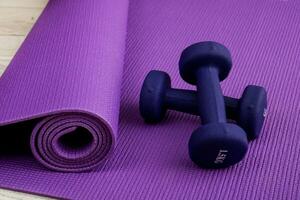 dumbbells on a lilac gymnastic mat, sports at home photo