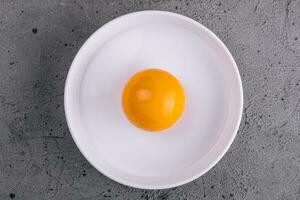 huevo yema de huevo en cuenco apartado para Cocinando foto