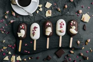 Top view of decorated cake pops ice creams on black background photo