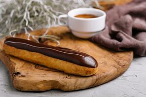 Eclairs with chocolate and a coffee cup photo