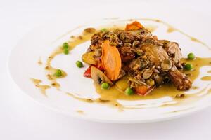 Baked duck leg in sauce with vegetables photo