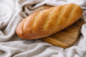 A loaf of bread on a wooden board photo