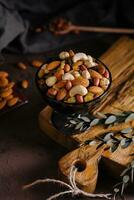 Bowl with mixed organic nuts on wooden board photo