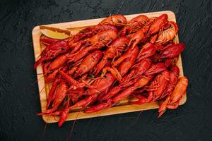 Fragrant boiled crayfish on a wooden board photo