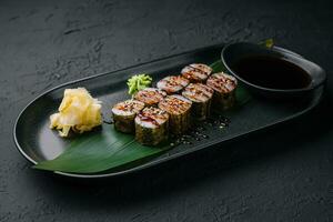 Traditional fresh japanese sushi futomaki on black plate photo