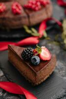 Delicious chocolate cake decorated with fresh berries on wooden table photo