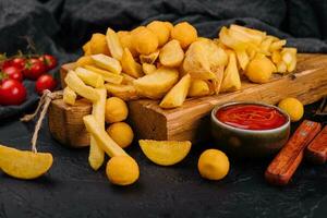 Assorted beer snacks like potato wedges, french fries and cheese balls photo