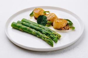 Freshly sauteed scallops with green asparagus photo