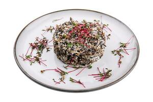 Delicious cooked black rice or risotto on plate photo