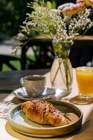 taza de Fresco caliente café, naranja jugo y tradicional francés cuerno en mesa de parisino al aire libre café en París foto