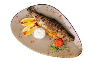 Grilled sea fish with lemon on plate photo