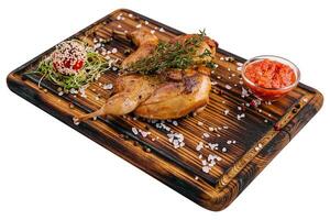 Roasted partridge with sauce tomato on wood board photo