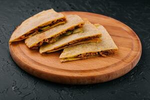 Mexican quesadilla with chicken on wooden table. photo