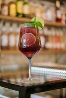 Cold pink cocktail with fresh grapefruit, lime and ice cubes on restaurant table photo