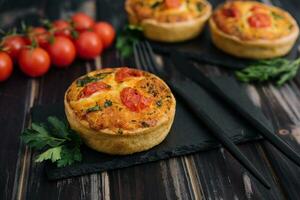 Cheddar cheese and spring onion omelette tarts served on wooden board photo