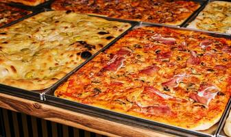 Delicious and unusual large pizzas with mushrooms and cheese, made on two metal trays. photo