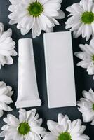 Cream tube with daisies. cosmetics mockup template, blank yellow label photo