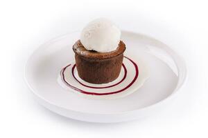 chocolate fondant y un cucharón de hielo crema en un blanco plato foto