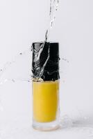 Bottle of shampoo splashing water and bubbles photo