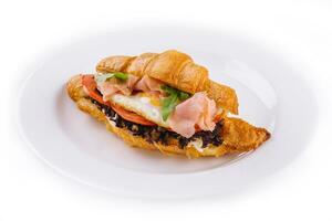 breakfast with croissant sandwiches with fried egg and salmon photo