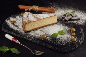 Delicious cheesecake with vanilla on black board photo