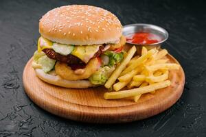 Juicy burger with onion rings and french fries photo