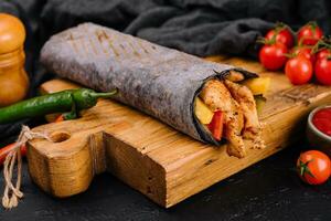 black lavash with chicken on black board photo