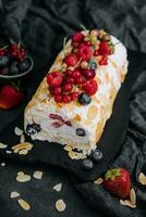 Meringue roll with cream and berries and almonds photo