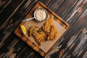 fried cod fillet pieces on wooden tray photo