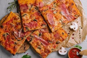 Long pizza mix lies on a wooden table photo