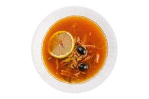 Solyanka mix soup with sausages, olives and lemon photo