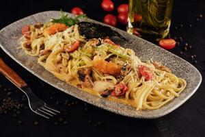 Seafood pasta with octopus and shrimps on plate photo