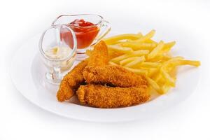 Chicken nuggets with french fries on plate photo