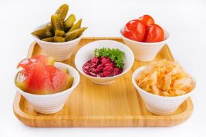 different pickles in Moldovan style on wood board photo