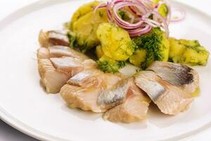 Salted fish with boiled potato and pickled onions photo
