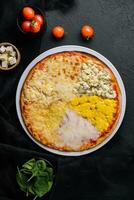 different types of cheese on a big pizza photo