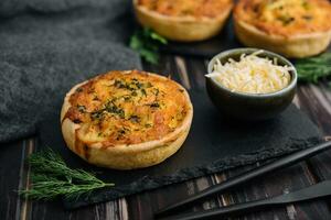 Cheddar cheese and spring onion omelette tarts served on wooden board photo