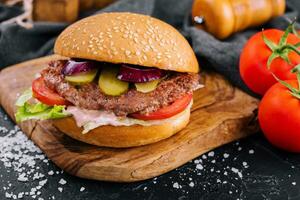 Close-up of home made burger on wooden tray photo