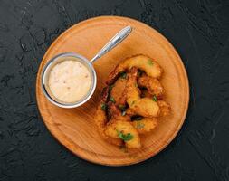 Fried shrimps or prawns with sauce on board photo