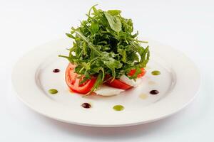 Green salad with arugula, tomato and feta cheese photo